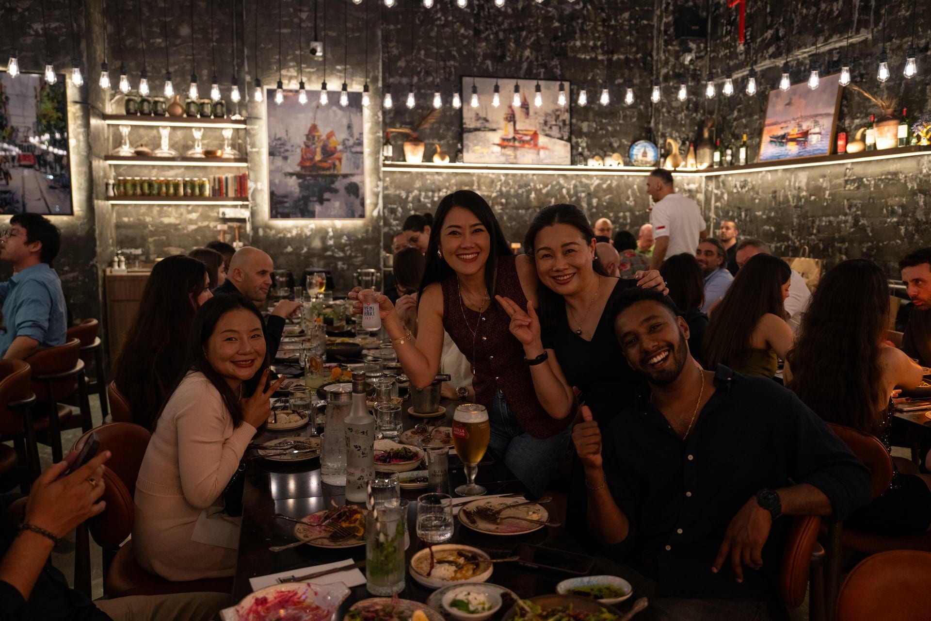 Pera restaurant filled with corporate event guests under warm hanging lights